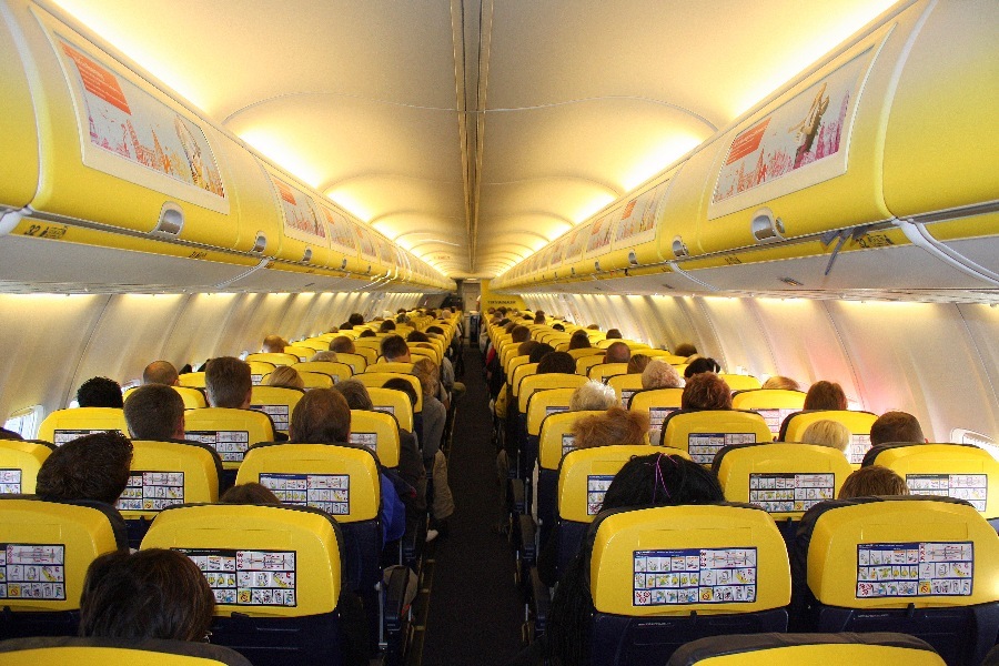 Interior do avião com bancos e cabines onde é colocada a bagagem da Ryanair